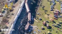 Overturned carriages and makeshift medical tents at crash site